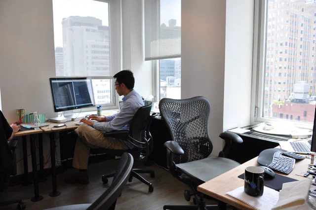 Engineer working at desk with city view