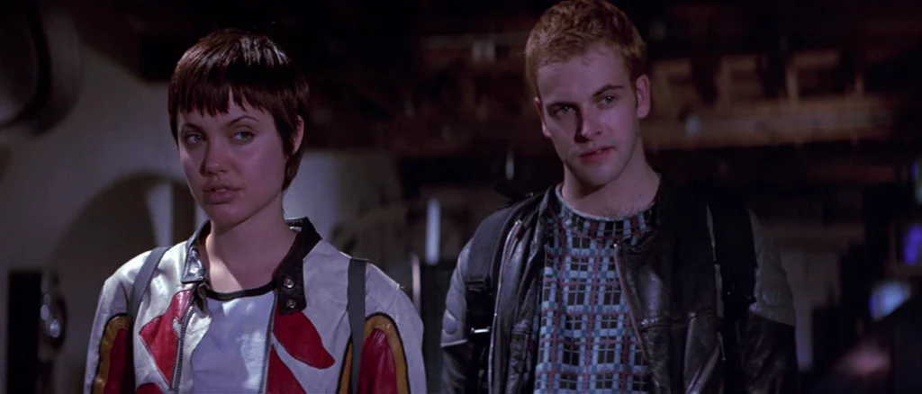 Still from the movie Hackers showing two characters in cyberpunk-style jackets