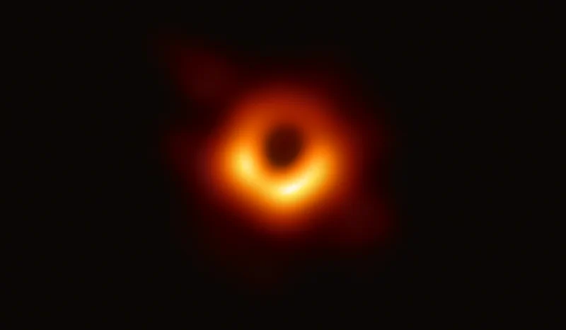 The first image of a black hole, showing a glowing orange ring surrounding a dark central shadow